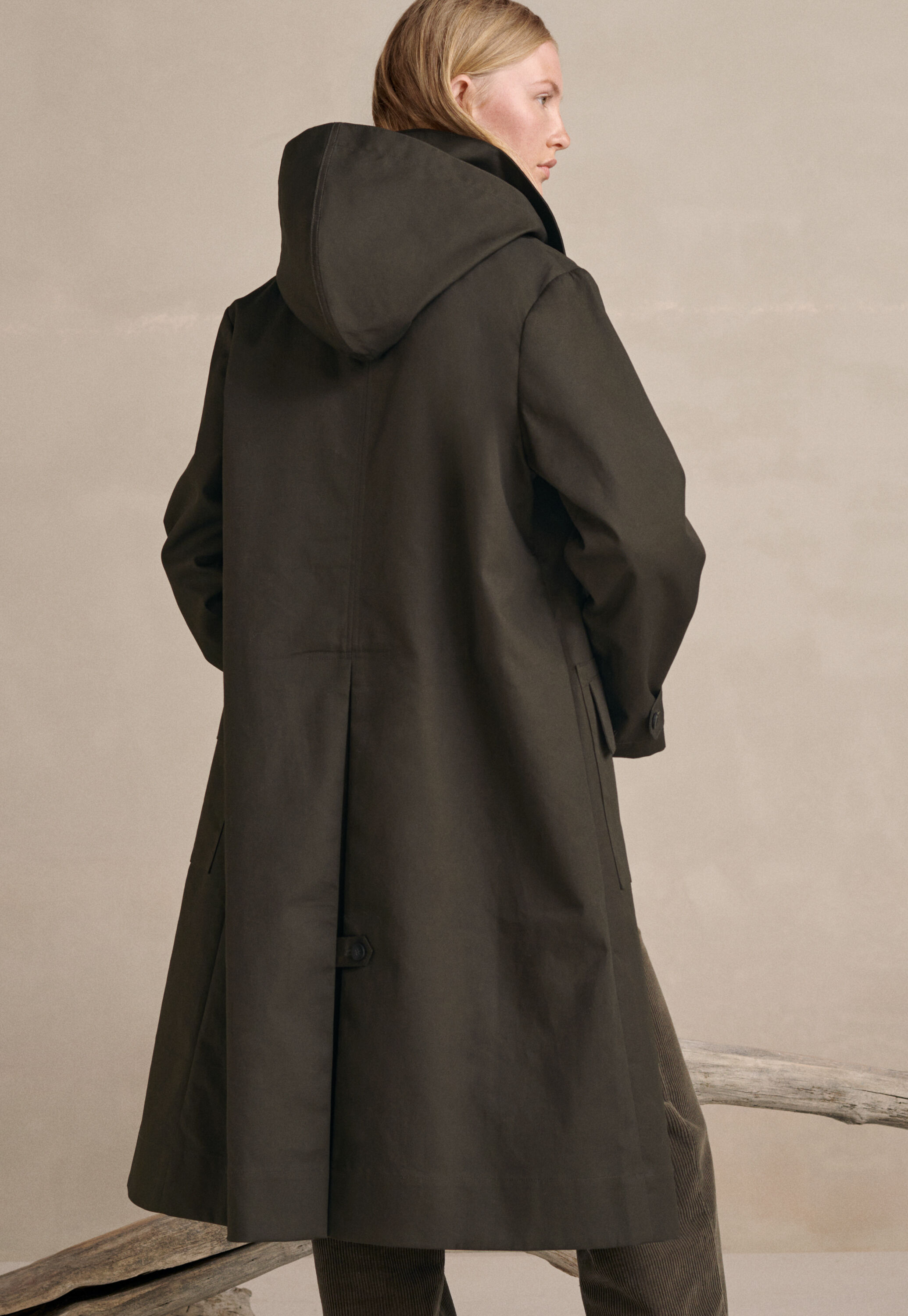 A contemporary trench coat in bonded, water-repellent cotton with a removable hood for when the sun comes out.